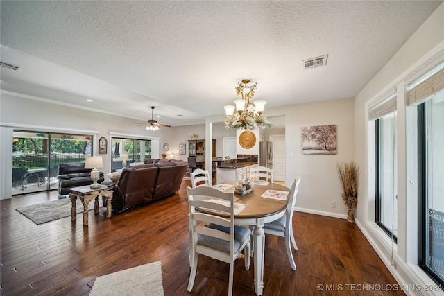 dining area with a textured ceiling, ceiling fan with notable chandelier, and dark hardwood / wood-style flooring