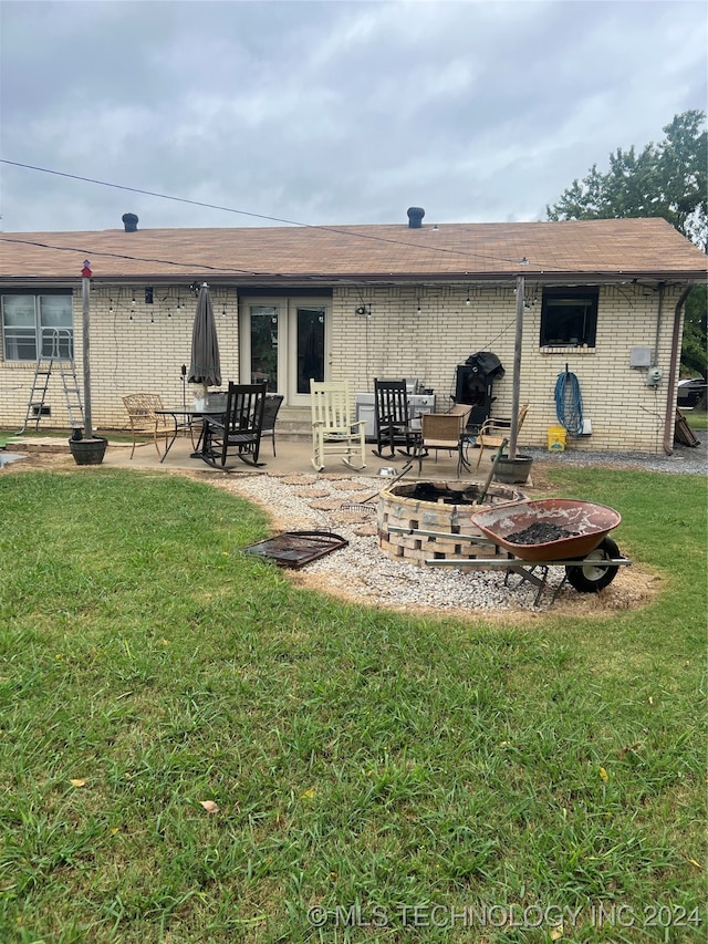 back of property featuring a patio, a yard, and a fire pit