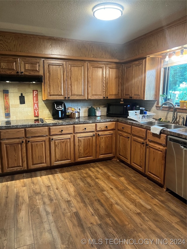 kitchen with sink, tasteful backsplash, stainless steel dishwasher, a textured ceiling, and dark hardwood / wood-style floors