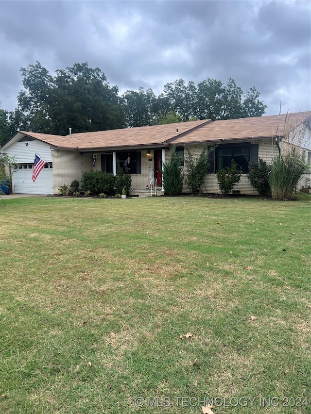 ranch-style home featuring a front lawn and a garage