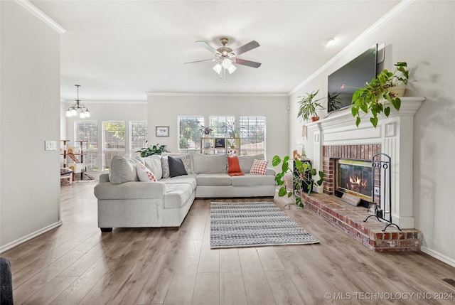 living room with wood-type flooring, ornamental molding, and a brick fireplace