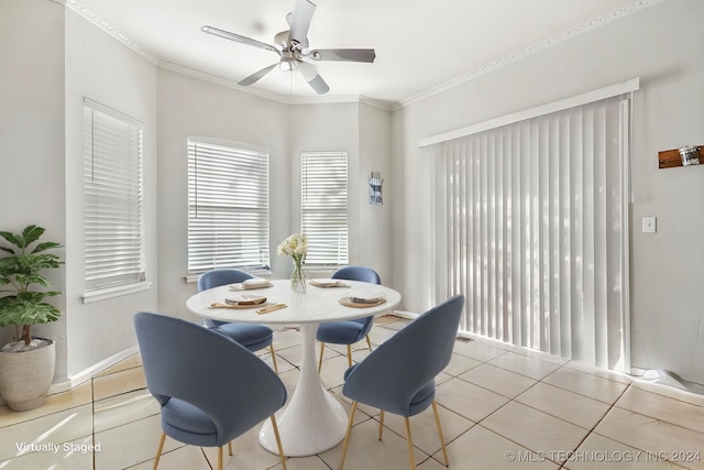 tiled dining room with ceiling fan and crown molding