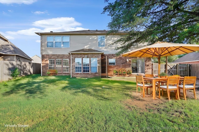 rear view of property with a lawn and a patio area