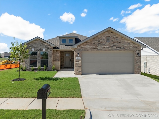 view of front of property featuring a garage and a front lawn