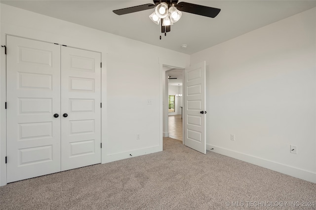 unfurnished bedroom featuring ceiling fan, a closet, and light carpet