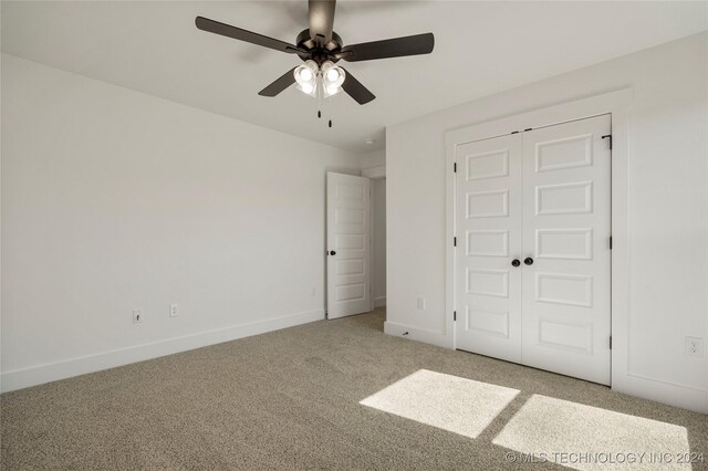 unfurnished bedroom with ceiling fan, a closet, and carpet