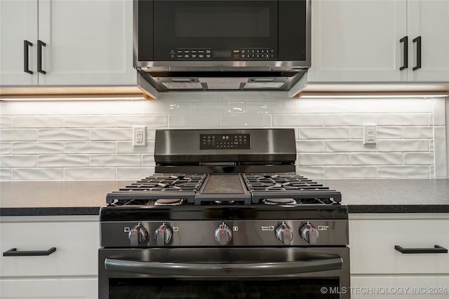 kitchen with backsplash, appliances with stainless steel finishes, and white cabinetry