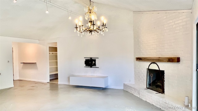 unfurnished living room with a brick fireplace, concrete flooring, and a notable chandelier