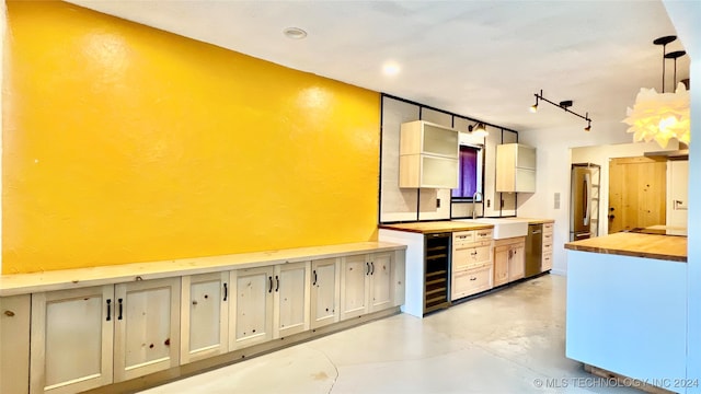 kitchen featuring wine cooler, sink, decorative light fixtures, wooden counters, and stainless steel fridge