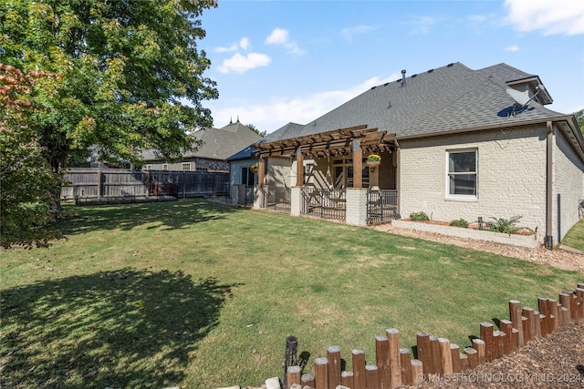 rear view of house featuring roof with shingles, brick siding, a lawn, and a fenced backyard