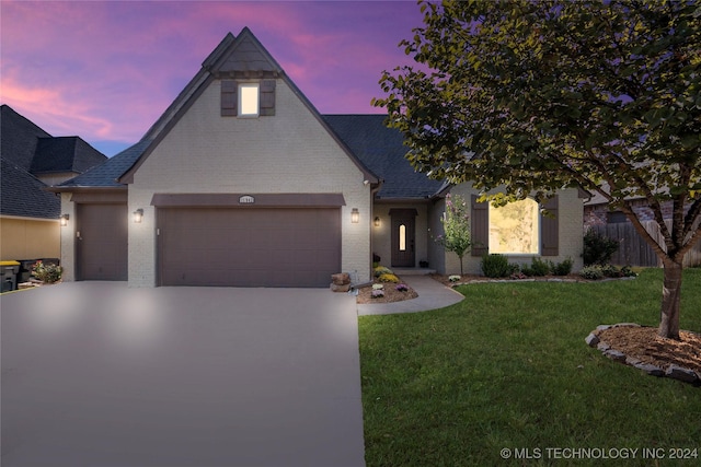 view of front of house with a garage, brick siding, fence, concrete driveway, and a front lawn