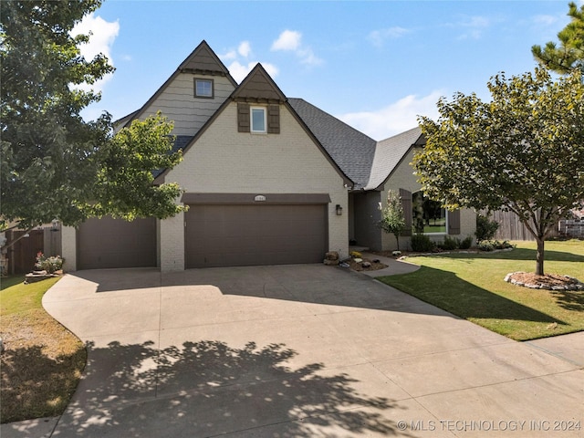 view of front of property with an attached garage, brick siding, concrete driveway, roof with shingles, and a front lawn