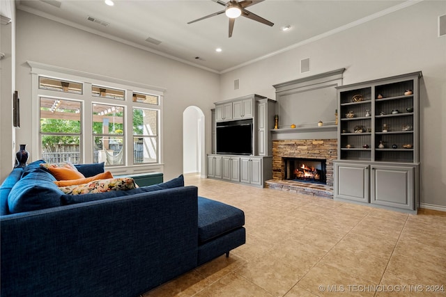 living room featuring visible vents, arched walkways, crown molding, a fireplace, and light tile patterned flooring