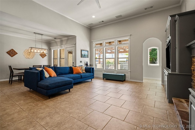 living room with light tile patterned floors, ornamental molding, visible vents, and baseboards