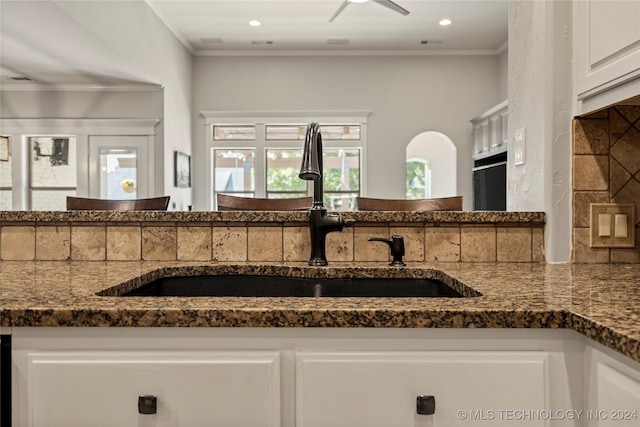 kitchen featuring ornamental molding, a sink, and white cabinets