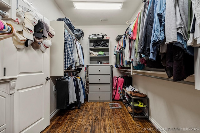 walk in closet with dark hardwood / wood-style flooring