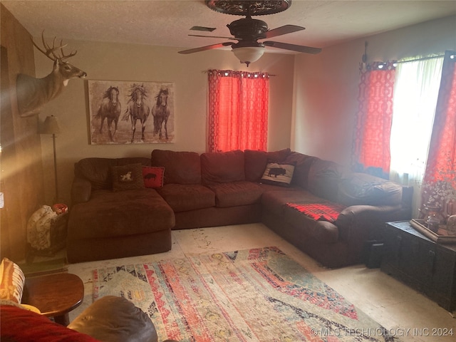 living room with a textured ceiling and ceiling fan