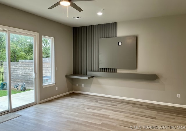 unfurnished living room with light wood-type flooring, a healthy amount of sunlight, and ceiling fan