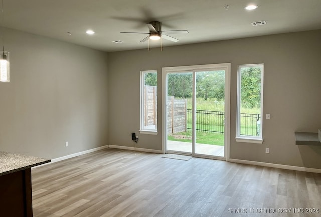 unfurnished room with light wood-type flooring, ceiling fan, and a healthy amount of sunlight