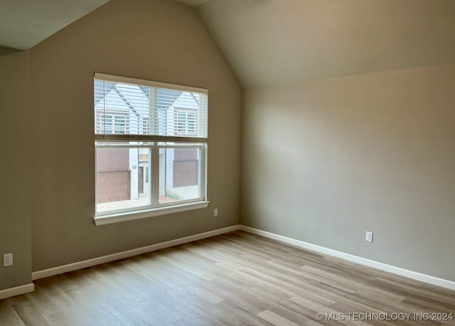 unfurnished room featuring light hardwood / wood-style flooring and vaulted ceiling