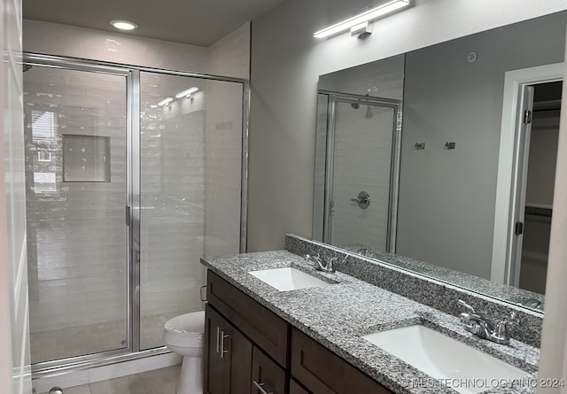 bathroom featuring walk in shower, vanity, toilet, and tile patterned floors