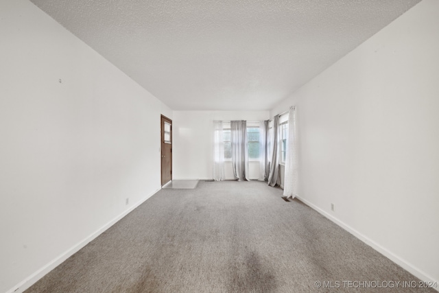 carpeted empty room with a textured ceiling