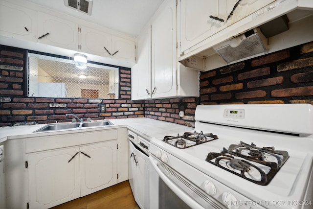 kitchen with dark wood-type flooring, white cabinetry, white range with gas cooktop, and sink