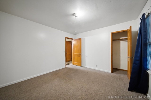 unfurnished bedroom with a closet and carpet