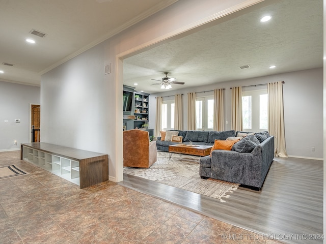 living room with ceiling fan, a textured ceiling, crown molding, and wood-type flooring