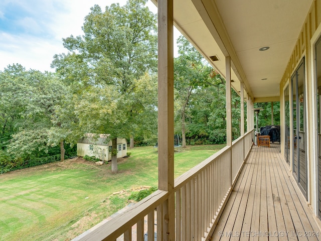 deck with an outdoor structure and a lawn