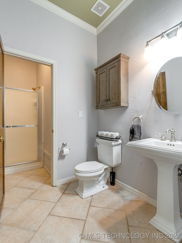 bathroom with tile patterned floors, crown molding, a shower with shower door, and toilet