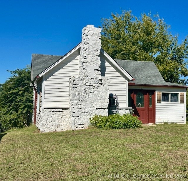 view of side of home with a yard