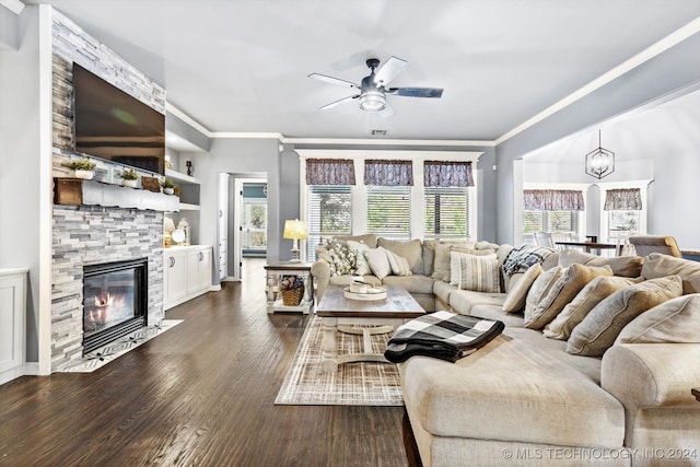 living room featuring ornamental molding, ceiling fan with notable chandelier, dark wood-type flooring, built in features, and a fireplace