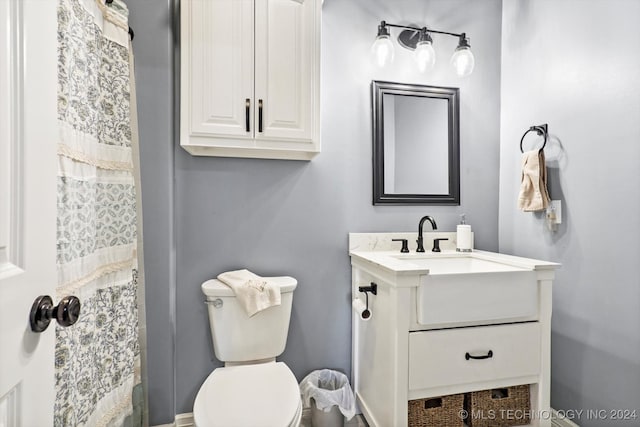 bathroom featuring a shower with shower curtain, vanity, and toilet