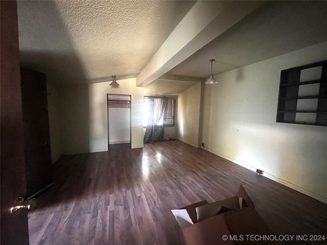 interior space with a textured ceiling, lofted ceiling, and dark hardwood / wood-style floors