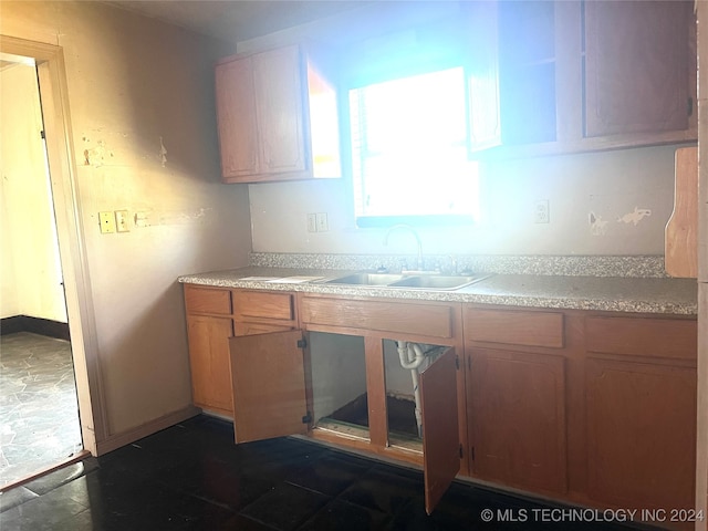 kitchen featuring dark tile patterned flooring and sink