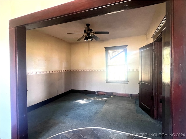 carpeted spare room with ceiling fan