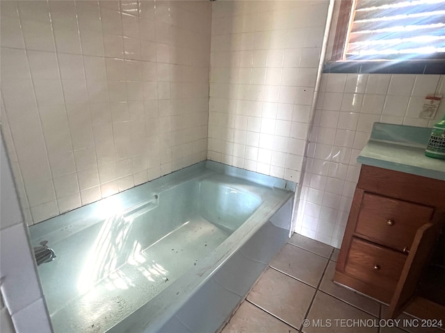 bathroom featuring a bathtub, tile walls, tile patterned flooring, and vanity