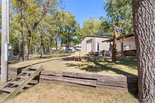 view of yard with a garage and an outbuilding