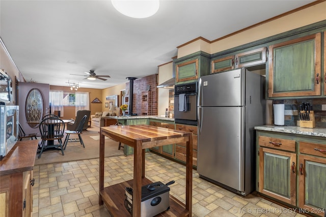 kitchen featuring ceiling fan, stainless steel refrigerator, tasteful backsplash, and black oven