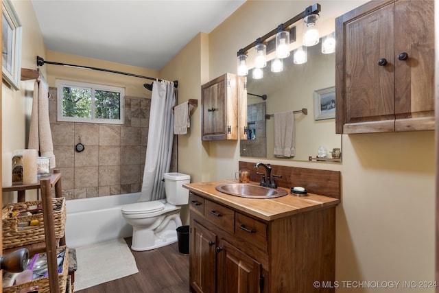 full bathroom with wood-type flooring, vanity, shower / bath combo with shower curtain, and toilet