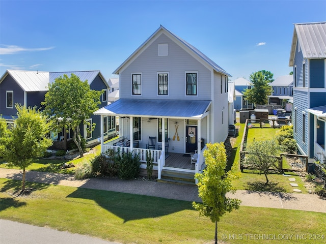 view of front of property with central air condition unit, a front yard, and covered porch