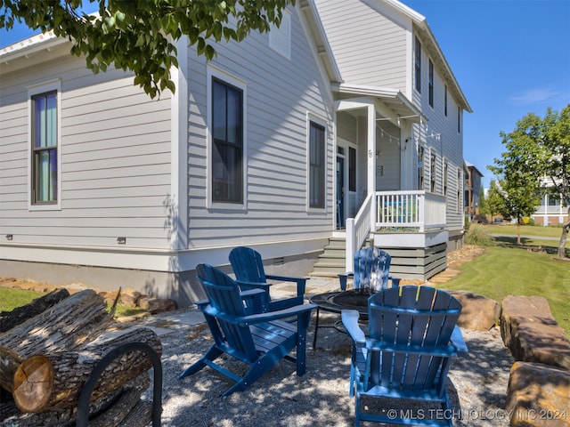 view of side of home with an outdoor fire pit, a patio, and a lawn