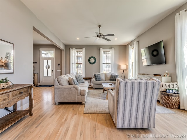 living room with ceiling fan and light hardwood / wood-style flooring