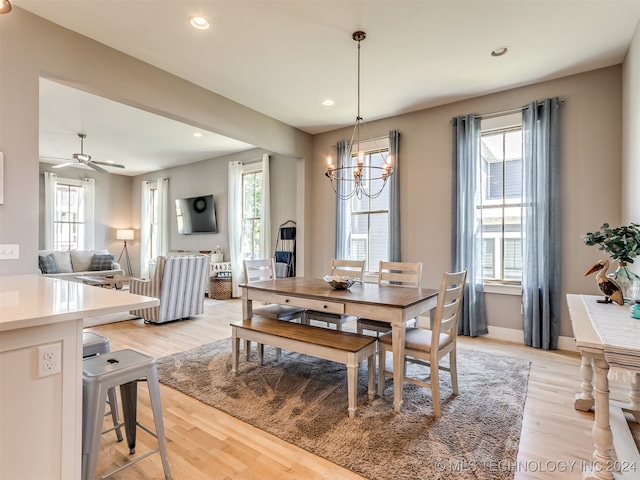 dining room featuring ceiling fan with notable chandelier and light wood-type flooring