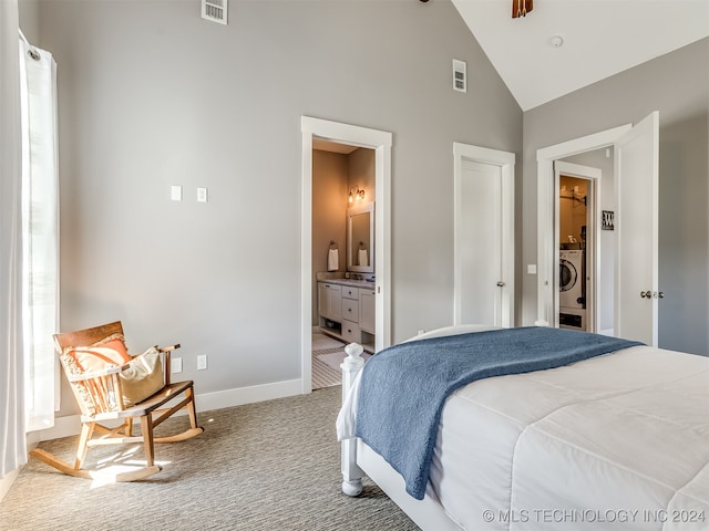 bedroom with washer / dryer, light carpet, high vaulted ceiling, and connected bathroom