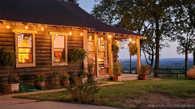 exterior entry at dusk featuring a lawn