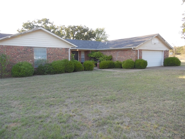 single story home featuring a garage and a front lawn