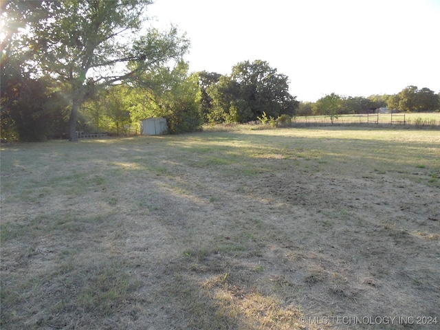 view of yard featuring a rural view and a shed