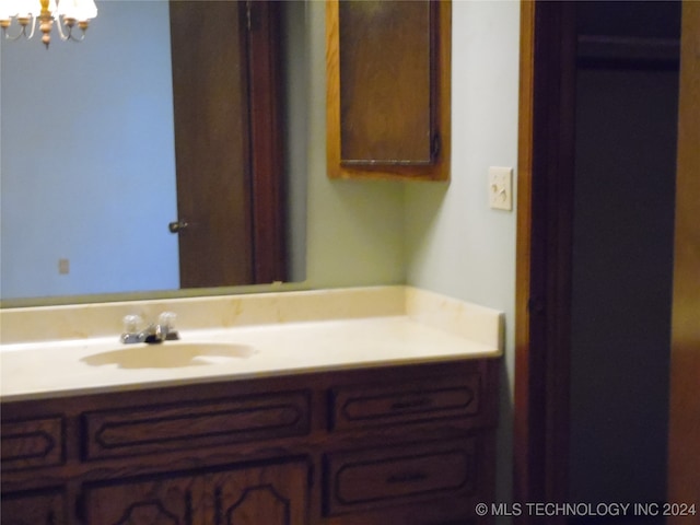 bathroom featuring a notable chandelier and vanity